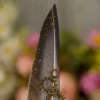 High angle close up of the grey feather and bronze gear cogs