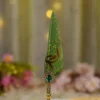 Detailed shot of the emerald crystal gemstone in a gold baroque frame