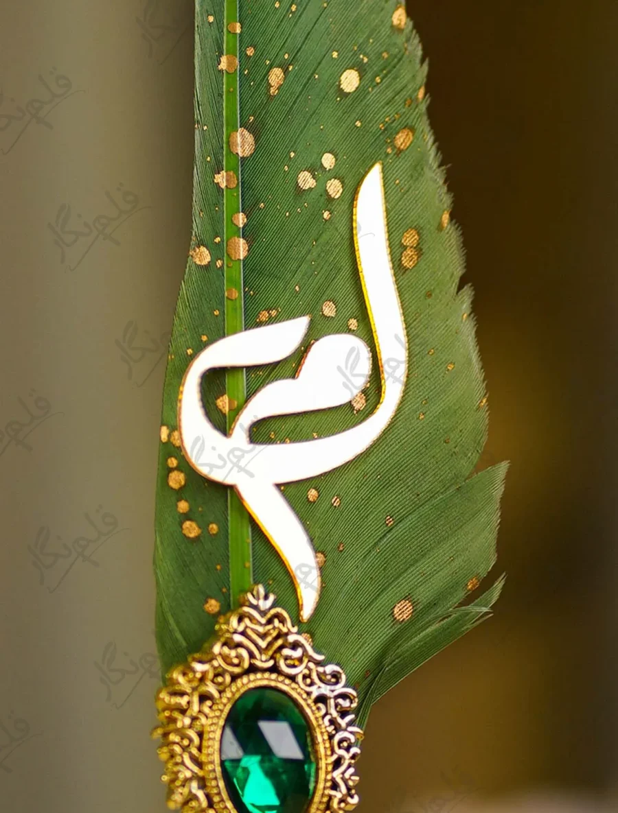 Gold-splattered green quill feather showing the metallic glitter paint