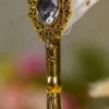 Gold-splattered white quill feather showing the metallic glitter paint