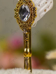 Gold-splattered white quill feather showing the metallic glitter paint