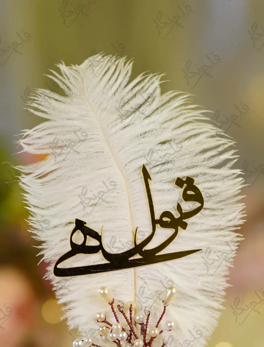 Close up of the golden mirror acrylic Qabool Hai calligraphy on the white feather