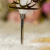 Detailed view of the silver crown collar at the base of the white feather on the chrome pen