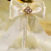Detailed shot of the cream satin bow and central gold pearl flower brooch