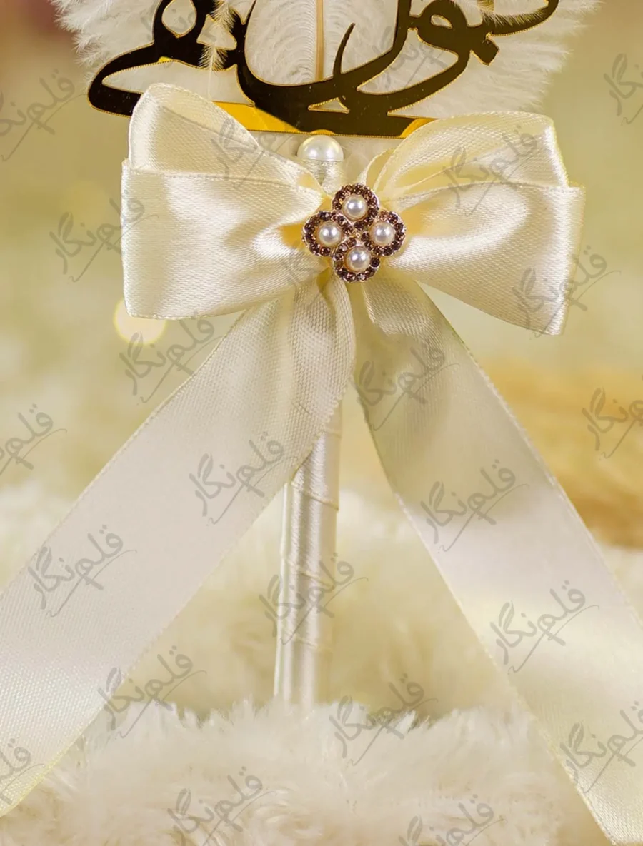 Detailed shot of the cream satin bow and central gold pearl flower brooch