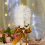 - 1.jpg: Handmade white feather Nikkah pen with a bronze satin bow and pearl wrapped handle