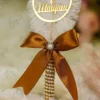 High angle close up of the pearl wrapped handle and bronze satin bow