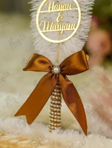 High angle close up of the pearl wrapped handle and bronze satin bow