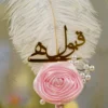 Front view of the pink fabric rose and decorative pearl branches at the feather base