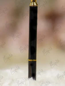 High angle close up of the multi faceted crystal glass diamond top on black pen