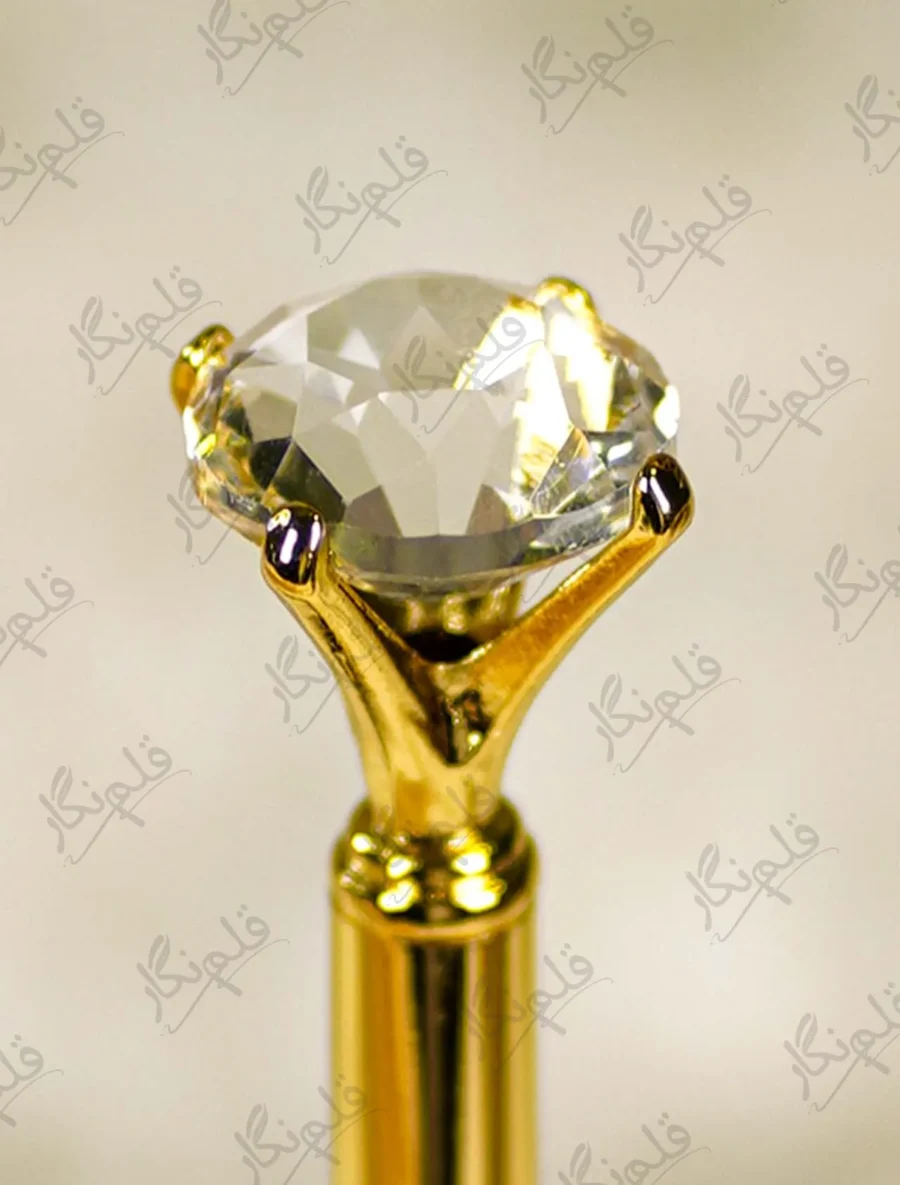 High angle close up of the multi faceted crystal glass diamond top on gold pen