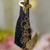 Close up of mechanical gold gears and wing decoration on black feather signing pen