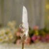 Close up of mechanical gold gears and wing decoration on white feather signing pen