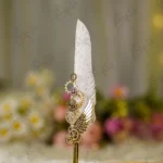 Close up of mechanical gold gears and wing decoration on white feather signing pen