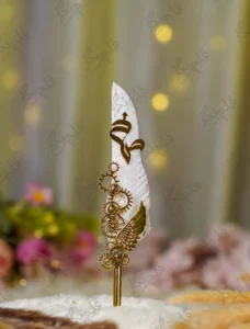 White feather Nikkah pen featuring a gold mirror acrylic Bismillah calligraphy cutout at the top