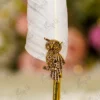 Close up of the golden owl claw detail grasping the branch on the metal shaft