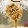 Close up of the handcrafted gold satin rolled rose and crescent pearl trim