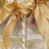 Detailed shot of the gold-brushed cream rose cluster and gold bow