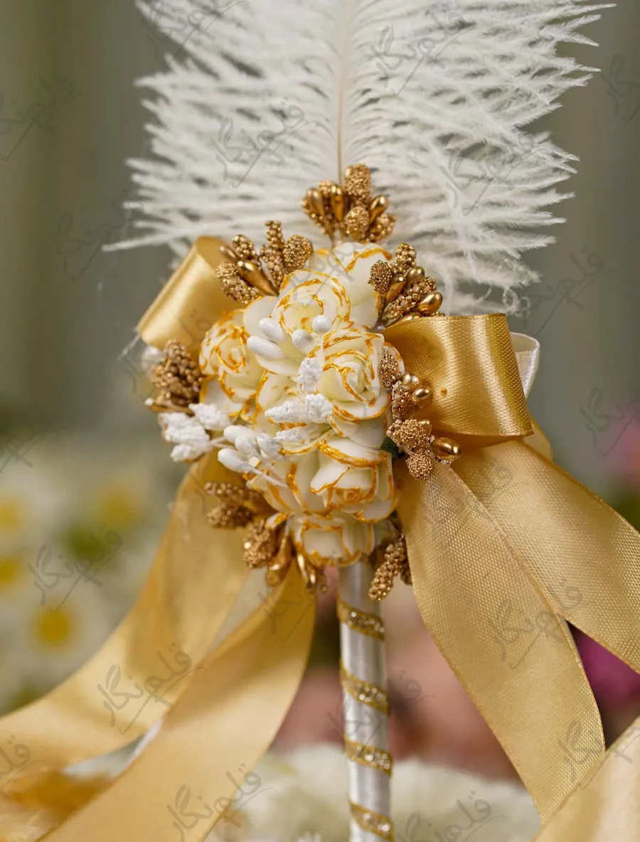 Fluffy white ostrich feather rising behind the golden rose cluster