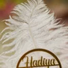 Close up of the gold mirror acrylic Qabool Hai calligraphy script on the feather