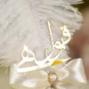 Detailed shot of the ivory satin ribbon bow and pearl rhinestone button center