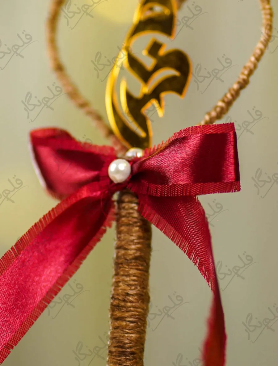 Detailed shot of the maroon satin bow with a center double pearl