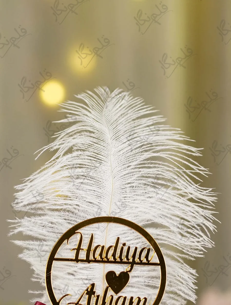 Close up of the gold mirror acrylic Qabool Hai calligraphy script on the feather
