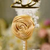 Detailed shot of the pearl bead sprigs branching from the gold satin rose