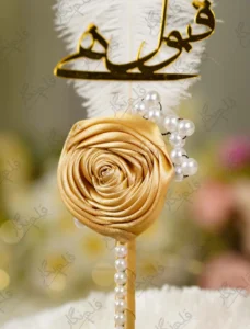 Detailed shot of the pearl bead sprigs branching from the gold satin rose