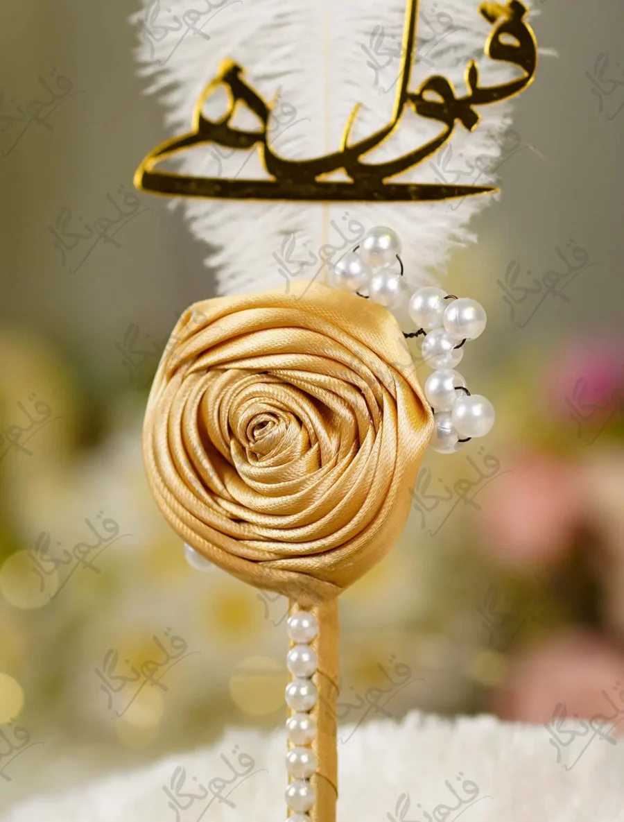 Detailed shot of the pearl bead sprigs branching from the gold satin rose