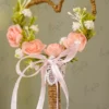Close up of the artificial pink peach roses and baby's breath flowers on the heart frame