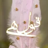 Detailed view of the gold claw-set rhinestones on the pink and white feathers