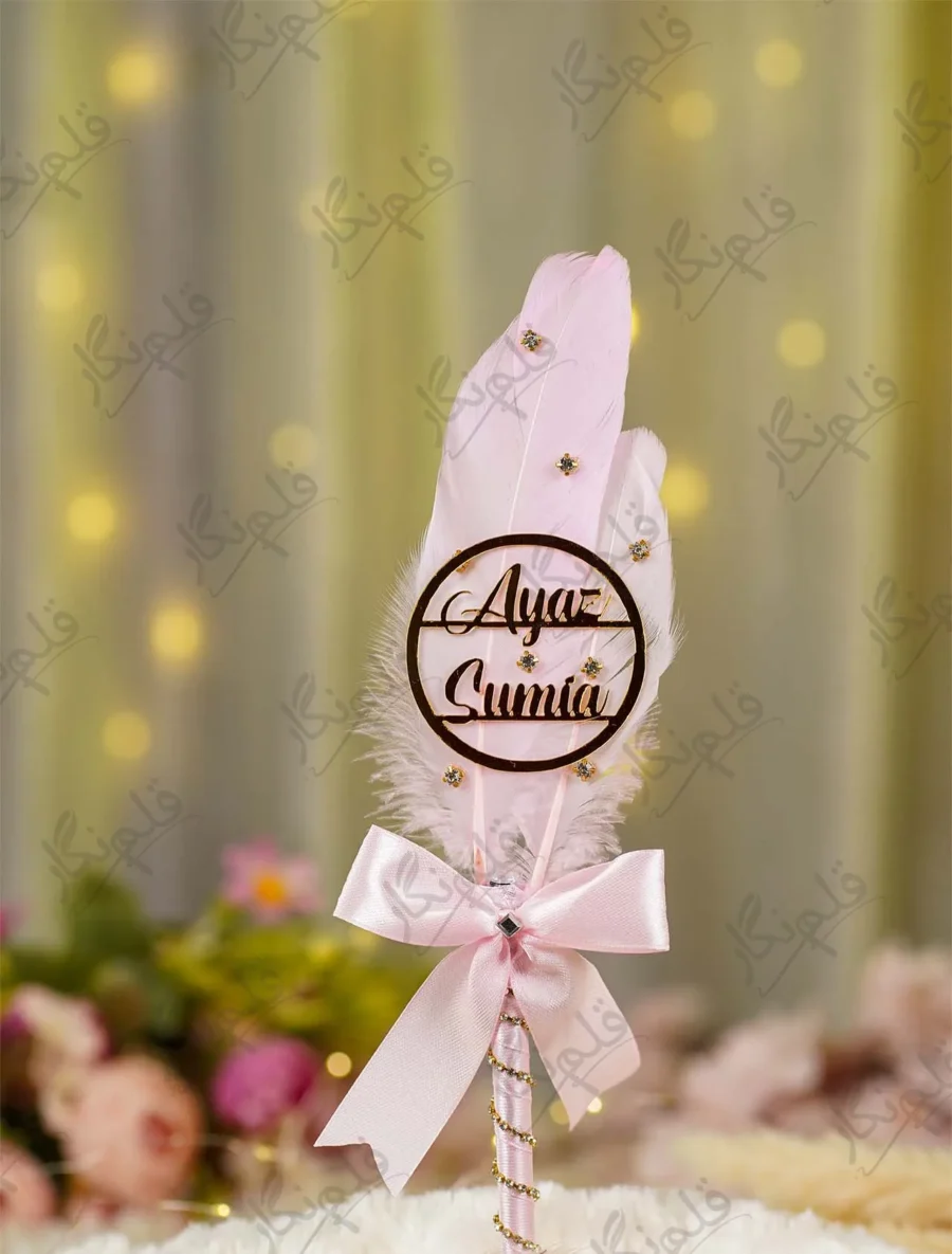 Side angle of the pink satin bow and gold rhinestone spiral wrapping on the handle