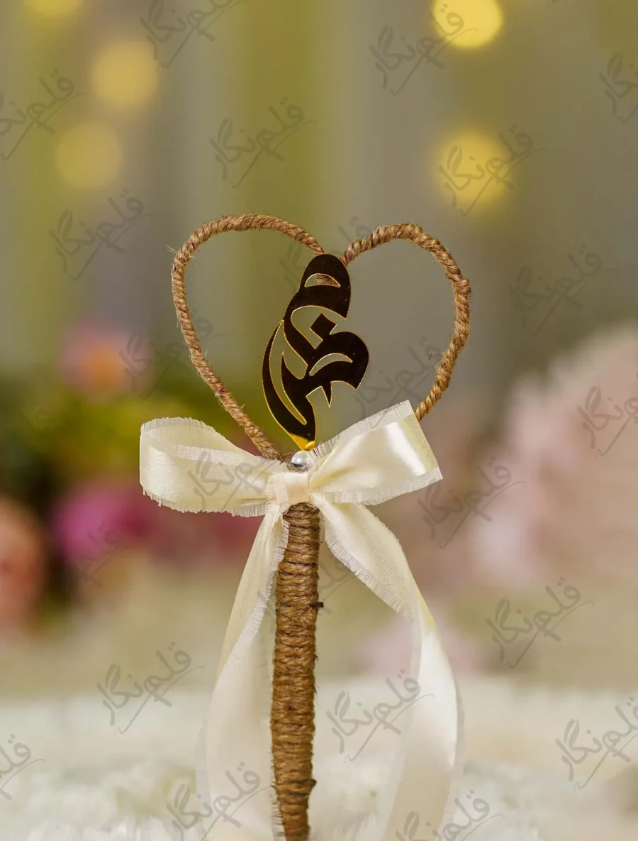 Front view of the gold mirror acrylic Qabool Hai script suspended in the jute wire heart