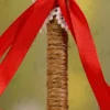 Detailed close up of the red ribbon bow and white lace over the jute-wrapped handle