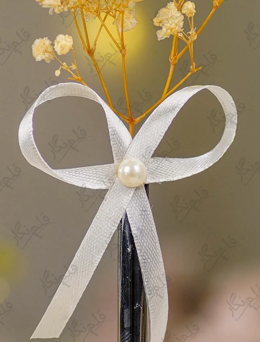 Close up of the white satin ribbon bow and central pearl bead accent