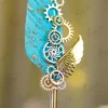 Side angle view of the turquoise feather showing gold metallic paint spots