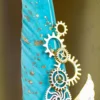 Detailed shot of the tiny blue rhinestone set in a gold gear ornament