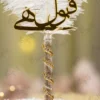 Close up of the golden mirror acrylic Qabool Hai calligraphy on the white feather