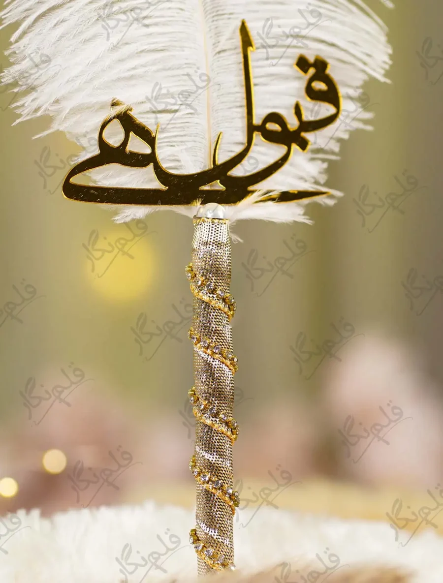 Close up of the golden mirror acrylic Qabool Hai calligraphy on the white feather
