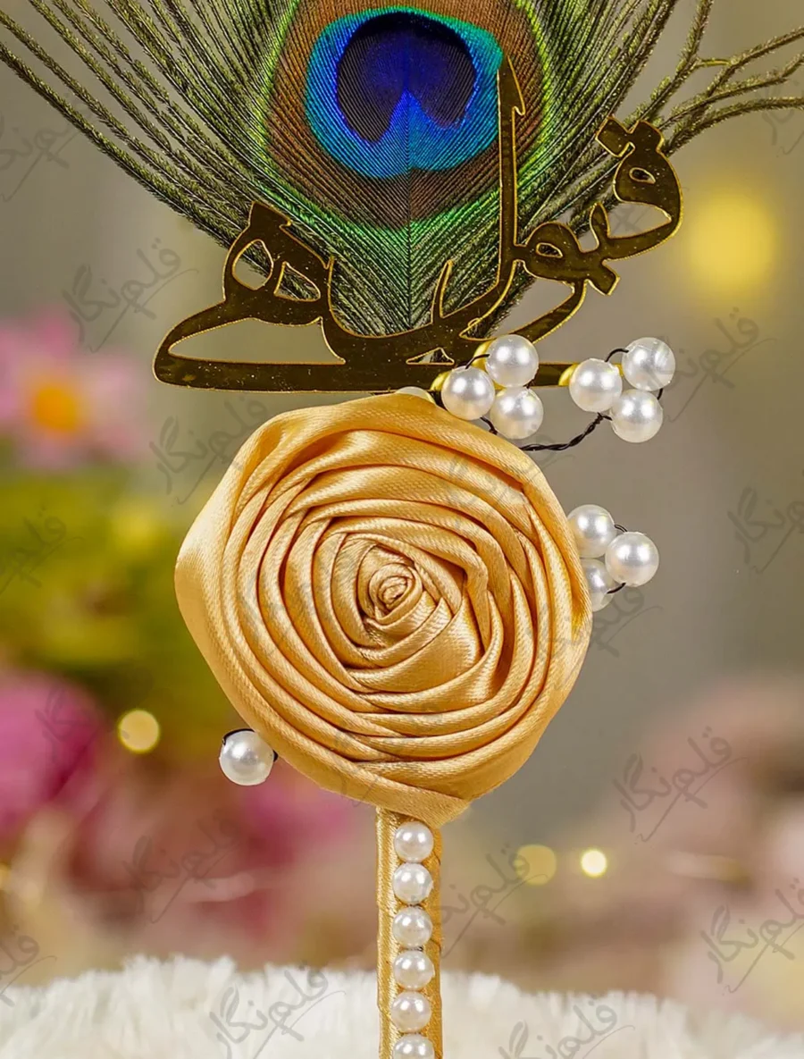 Close up of the golden mirror acrylic Qabool Hai calligraphy on the peacock feather