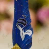 Detailed close up of the gold splatters on the royal blue quill feather