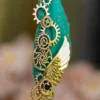 Upper half of the teal feather showing gold dust paint splatters