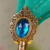 Detailed shot of the gold mirror nameplate on teal feather