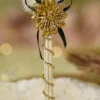 Detailed shot of the black ribbon bow and textured gold flower centerpiece