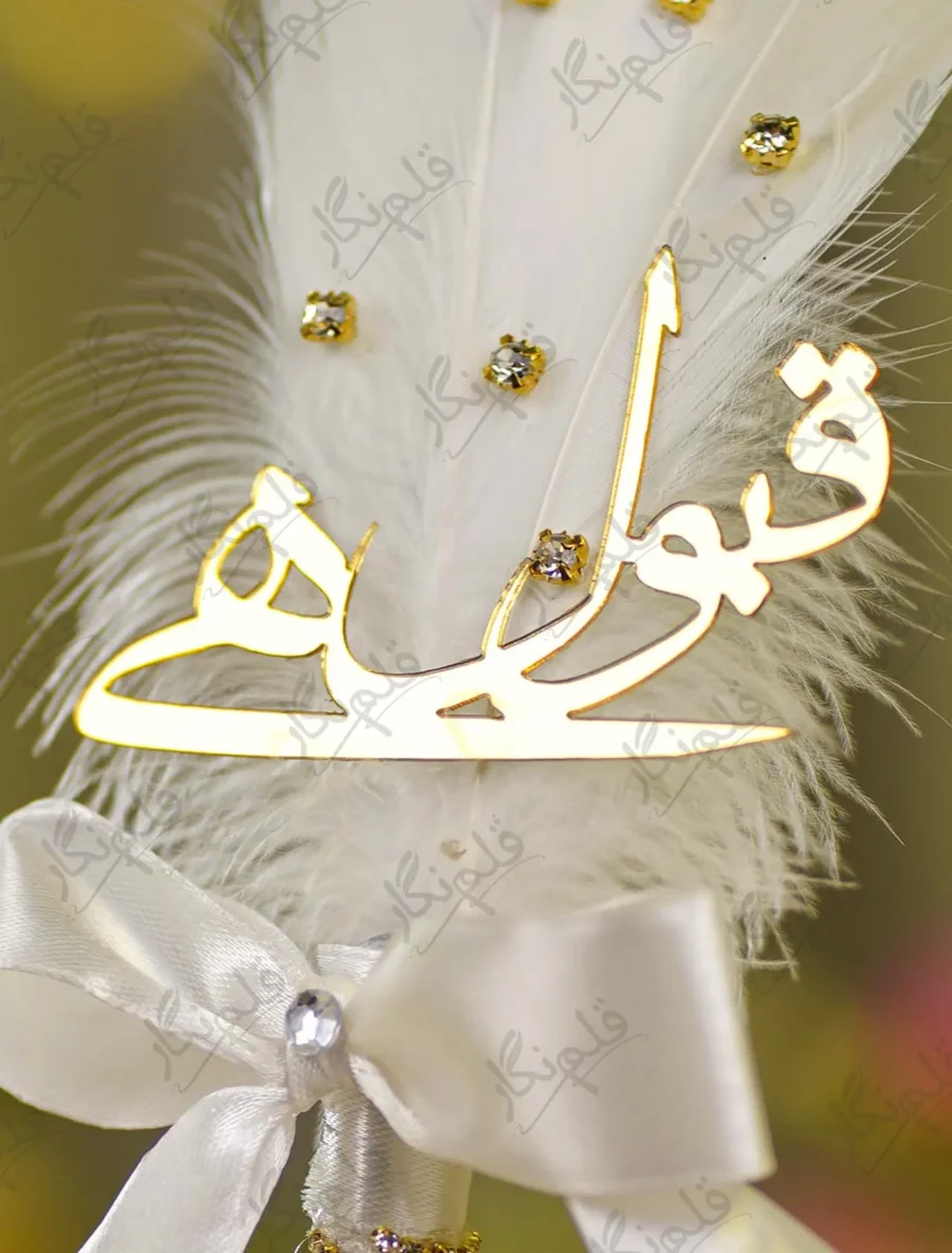 Close up of the golden mirror acrylic Qabool Hai script on the white feather