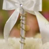 Detailed close up of the scattered gold rhinestones on the white feather