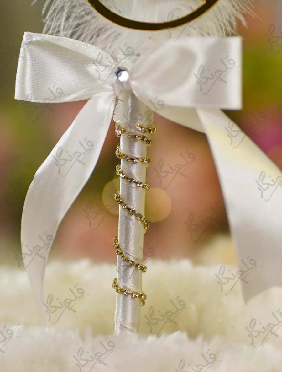Detailed close up of the scattered gold rhinestones on the white feather