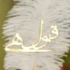 Close up of the golden mirror acrylic Qabool Hai calligraphy on the feather