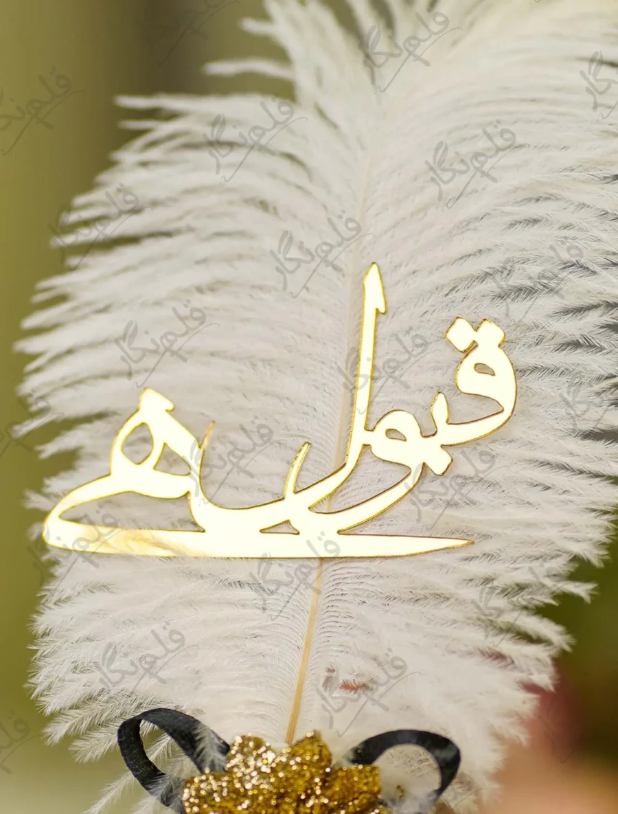 Close up of the golden mirror acrylic Qabool Hai calligraphy on the feather